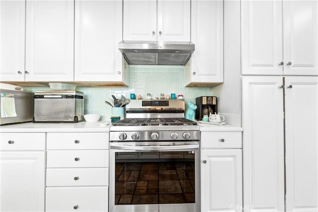 kitchen featuring stainless steel gas stove, white cabinetry, extractor fan, and backsplash