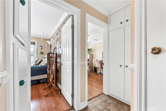 corridor with light wood-type flooring and ornamental molding