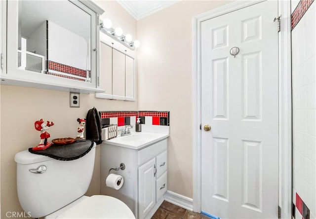 bathroom featuring toilet, vanity, and crown molding