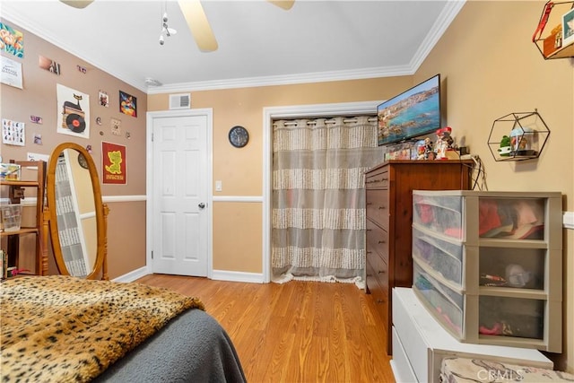 bedroom with light wood-type flooring, ceiling fan, and ornamental molding