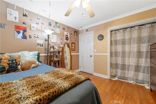 bedroom with ornamental molding, hardwood / wood-style flooring, and ceiling fan