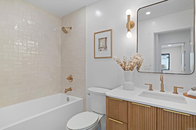 full bathroom featuring tiled shower / bath combo, vanity, and toilet