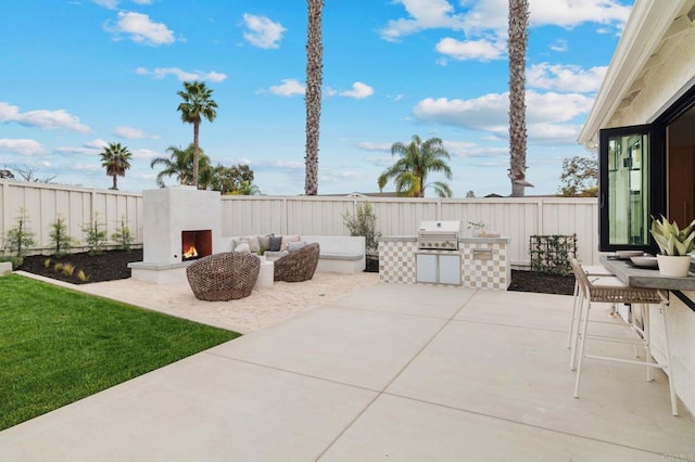 view of patio with exterior kitchen, an outdoor fireplace, and area for grilling