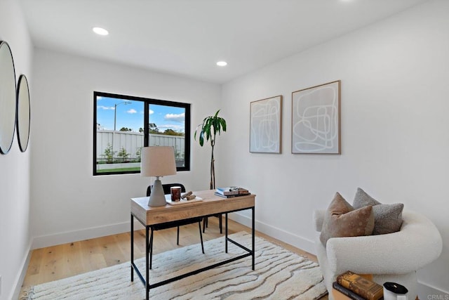 home office with light hardwood / wood-style flooring