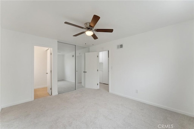 unfurnished bedroom featuring light colored carpet and ceiling fan