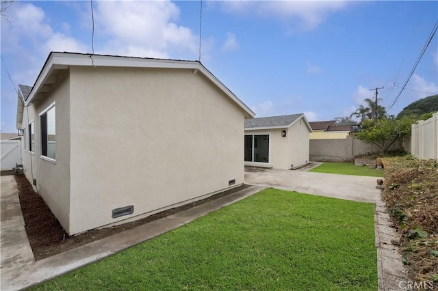 rear view of house with a patio and a lawn