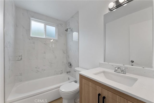 full bathroom featuring tiled shower / bath, vanity, and toilet