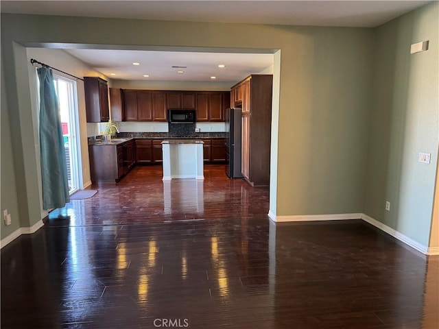 kitchen with a center island, fridge, and dark hardwood / wood-style floors