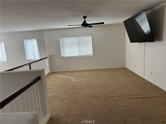 unfurnished living room with ceiling fan and carpet