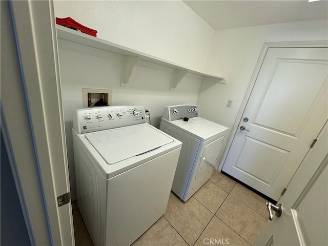 laundry area with light tile patterned flooring and washer and clothes dryer