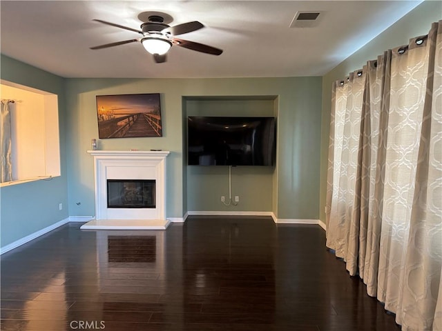 unfurnished living room with dark hardwood / wood-style floors and ceiling fan