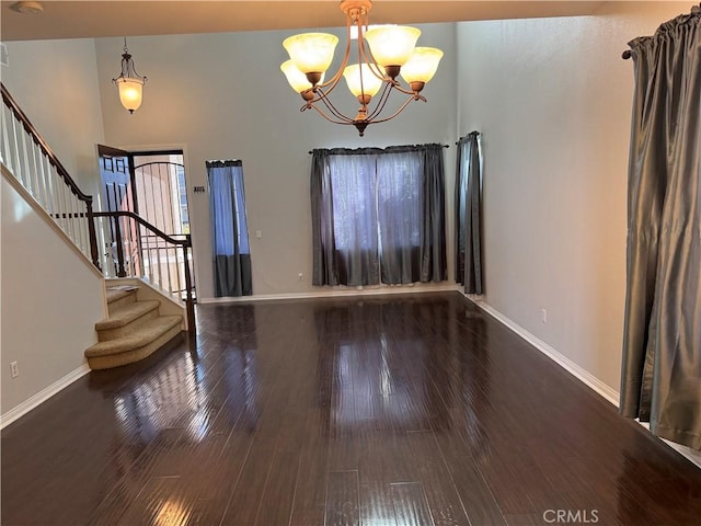 entrance foyer featuring hardwood / wood-style flooring, a chandelier, and a high ceiling