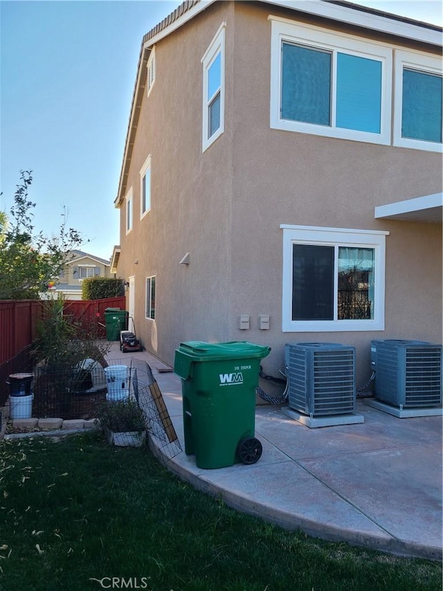 rear view of property featuring central AC unit and a patio area