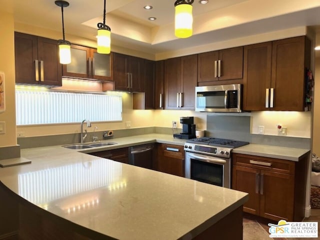 kitchen featuring stainless steel appliances, sink, dark brown cabinetry, and decorative light fixtures