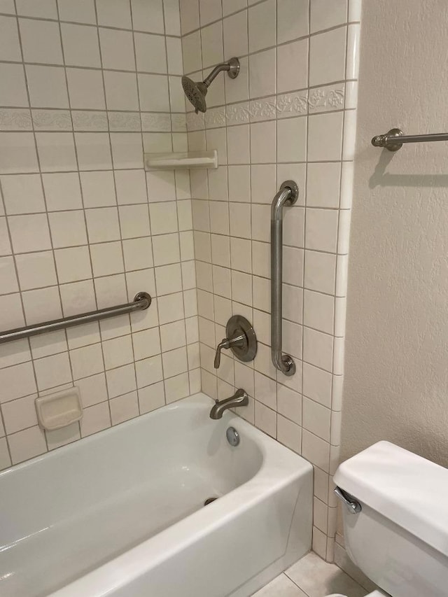 bathroom featuring tiled shower / bath and toilet