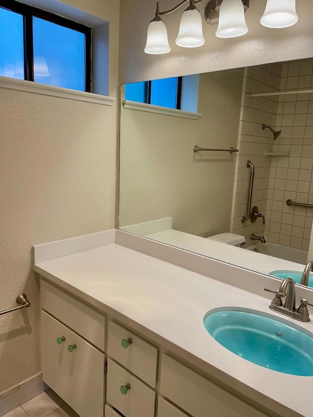 bathroom featuring tile patterned flooring, vanity, and tiled shower / bath