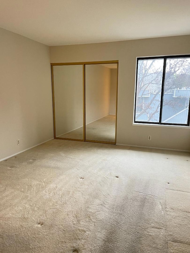 unfurnished bedroom featuring carpet floors and a closet