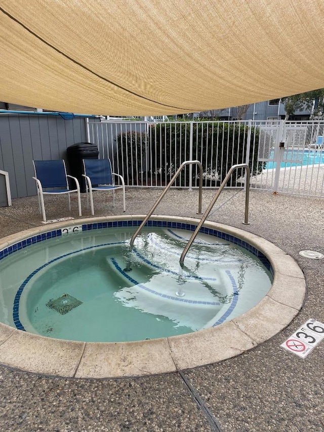 view of swimming pool featuring a community hot tub