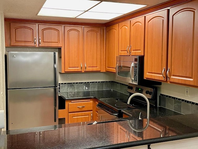 kitchen featuring stainless steel appliances and dark stone countertops