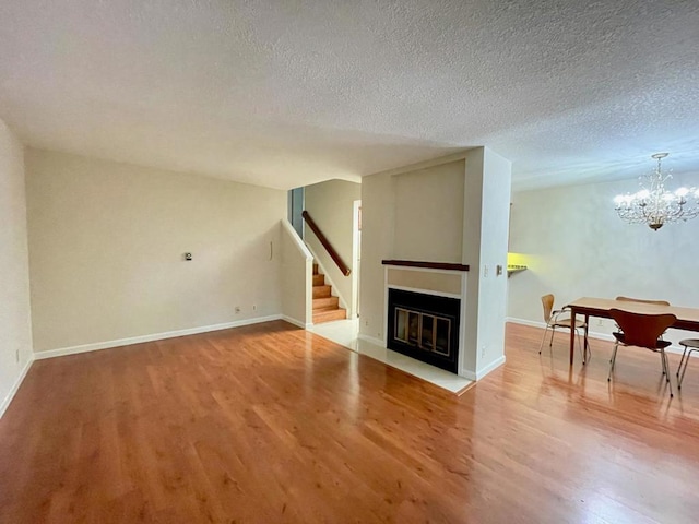 living room featuring hardwood / wood-style flooring, an inviting chandelier, and a textured ceiling