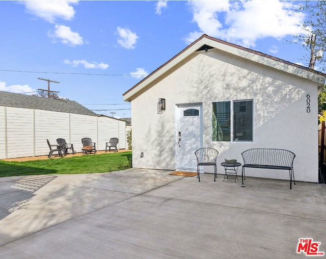 back of property featuring a yard, a fire pit, and a patio area