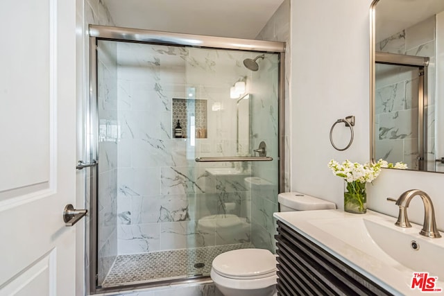 bathroom featuring vanity, toilet, and walk in shower