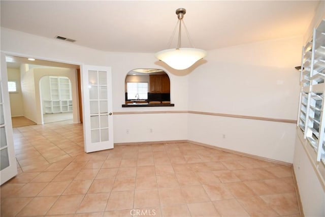 unfurnished room featuring light tile patterned floors and french doors