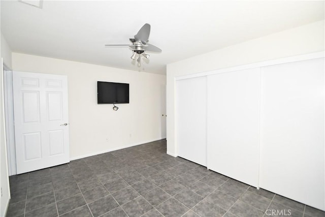 unfurnished bedroom featuring ceiling fan and a closet