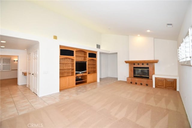 unfurnished living room featuring light colored carpet, a fireplace, and high vaulted ceiling