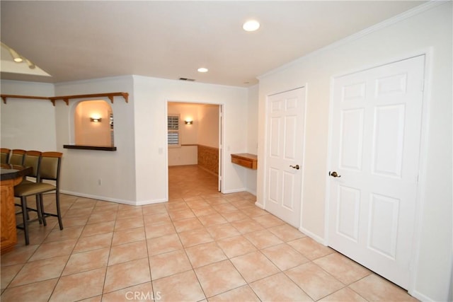 tiled empty room featuring ornamental molding