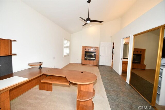 living room with high vaulted ceiling, a tile fireplace, and ceiling fan