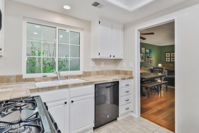 kitchen featuring sink, dishwasher, white cabinets, gas range, and tile countertops