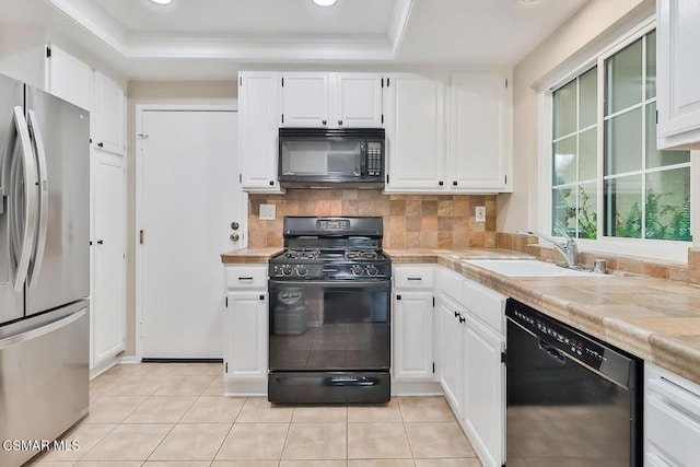 kitchen with white cabinetry, a tray ceiling, and black appliances