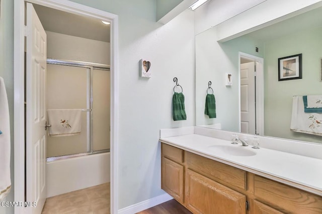 bathroom featuring vanity and bath / shower combo with glass door