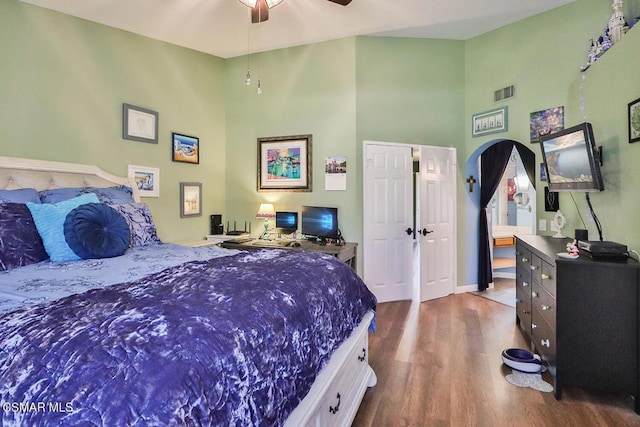 bedroom with a high ceiling, ceiling fan, and dark hardwood / wood-style flooring