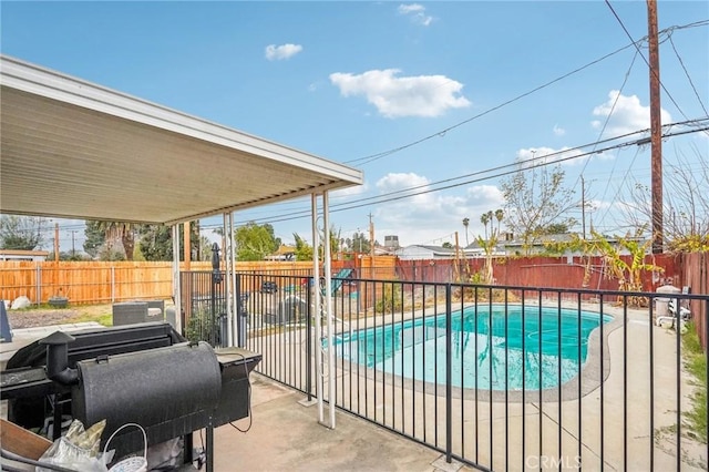 view of swimming pool featuring a grill and a patio