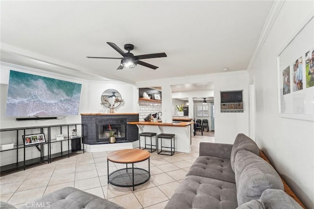 living room with light tile patterned flooring, ceiling fan, and crown molding