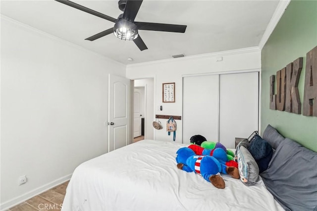 bedroom featuring ceiling fan, ornamental molding, a closet, and light hardwood / wood-style flooring