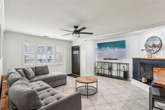 tiled living room with crown molding and ceiling fan