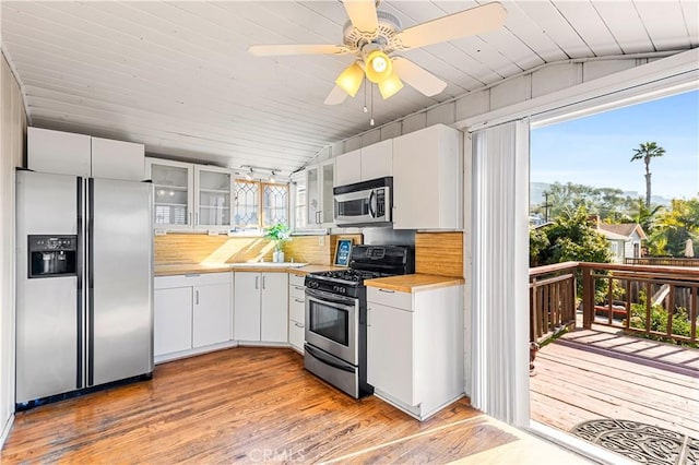 kitchen with white cabinetry, stainless steel appliances, light hardwood / wood-style floors, and a wealth of natural light