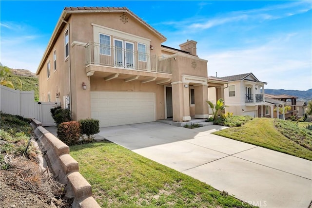 view of front of property with a mountain view, a garage, a front yard, and a balcony