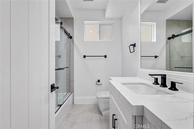 full bathroom featuring vanity, tile patterned floors, shower / bath combination with glass door, and toilet