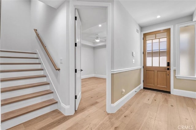 foyer entrance with ceiling fan and light wood-type flooring