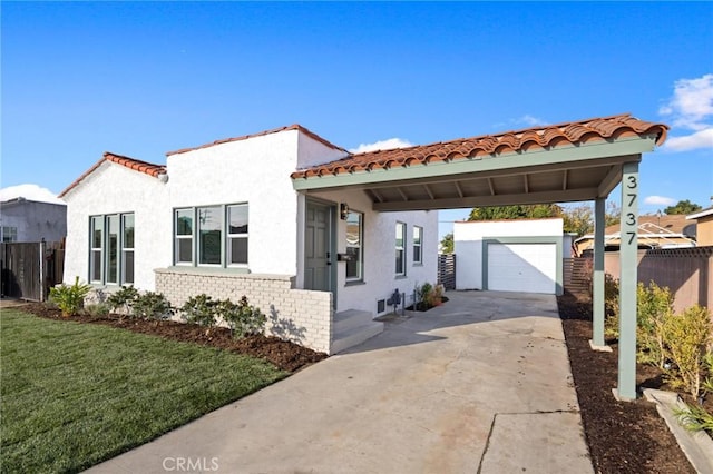 view of front of property with a garage, an outdoor structure, a carport, and a front lawn