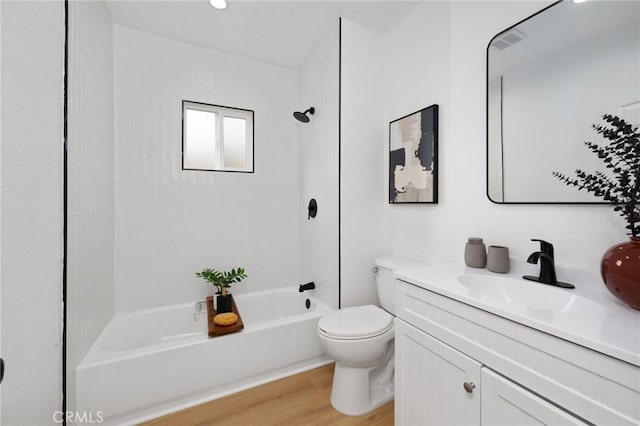 full bathroom featuring vanity, tiled shower / bath combo, wood-type flooring, and toilet