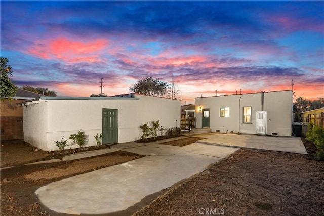 back house at dusk with a patio area