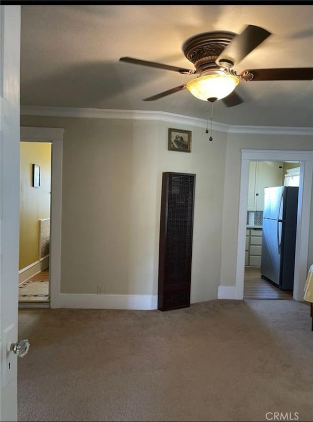 carpeted empty room featuring crown molding and ceiling fan