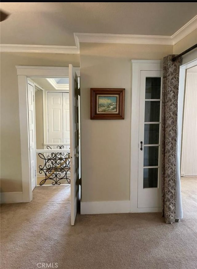 hallway with crown molding and light carpet