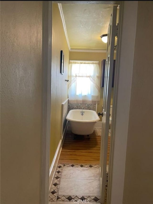 bathroom featuring ornamental molding and a bathing tub