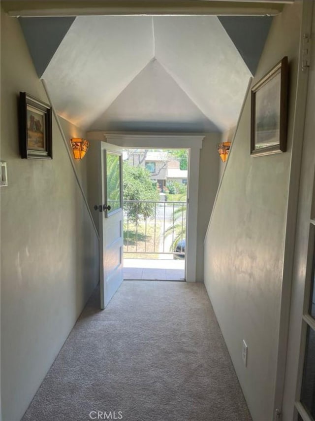 corridor with lofted ceiling and carpet flooring